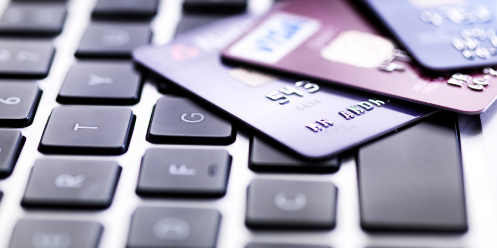 Three credit cards placed on the top of a laptop keyboard